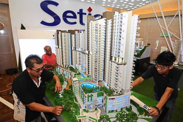 Ready for the big day: Workers setting up the scale model of a high-rise project at developer SP Setia’s booth in preparation for Star Property Fair 2015 at Sunway Carnival Mall Convention Centre in Seberang Jaya